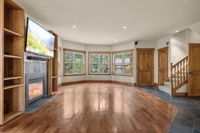 unfurnished living room featuring a tiled fireplace