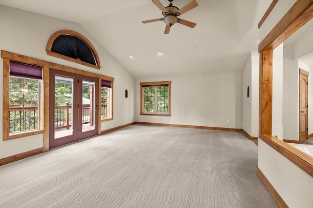 unfurnished living room with ceiling fan, french doors, high vaulted ceiling, and light colored carpet