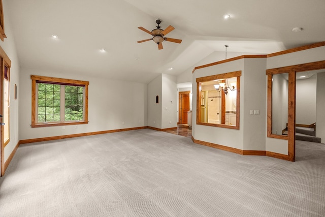 unfurnished living room featuring ceiling fan with notable chandelier, light colored carpet, and lofted ceiling