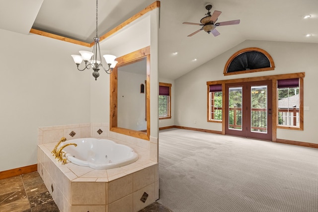 bathroom featuring ceiling fan with notable chandelier, tiled bath, and vaulted ceiling