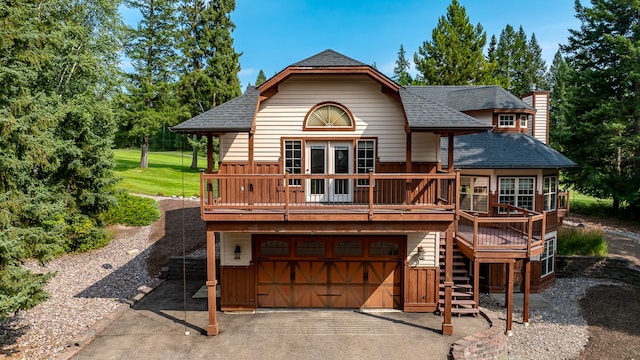 rear view of house featuring a garage and a deck