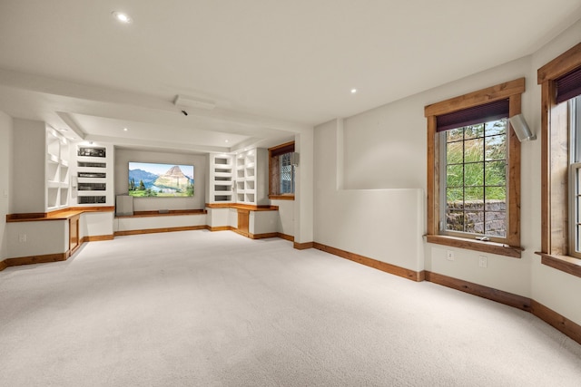 unfurnished living room featuring carpet flooring and built in shelves