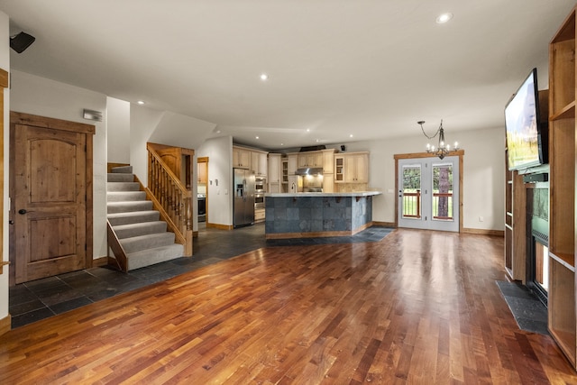 unfurnished living room featuring dark wood-type flooring and a chandelier