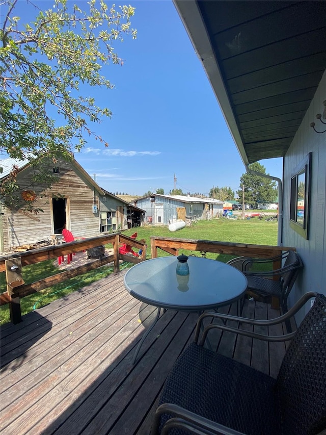 wooden terrace featuring a lawn