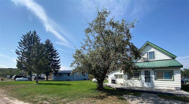 view of front of property featuring a front yard and metal roof