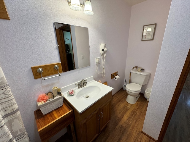 bathroom featuring vanity, wood-type flooring, and toilet