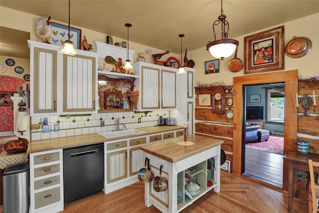 kitchen featuring pendant lighting, a center island, sink, black dishwasher, and butcher block counters