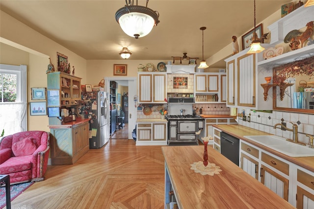 kitchen with butcher block counters, sink, black dishwasher, tasteful backsplash, and decorative light fixtures