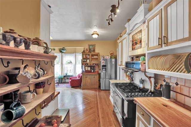 kitchen featuring white cabinets, appliances with stainless steel finishes, light wood-type flooring, and butcher block countertops