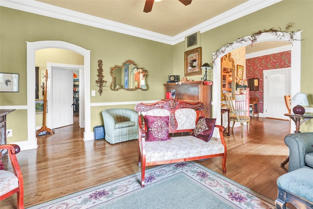 living room featuring hardwood / wood-style flooring, ceiling fan, and ornamental molding