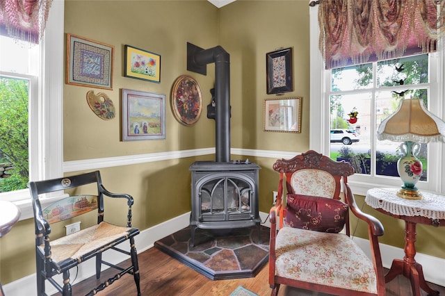 living area featuring a wood stove and hardwood / wood-style floors