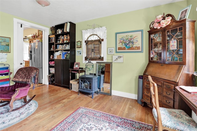 living area with light wood-type flooring and a wood stove