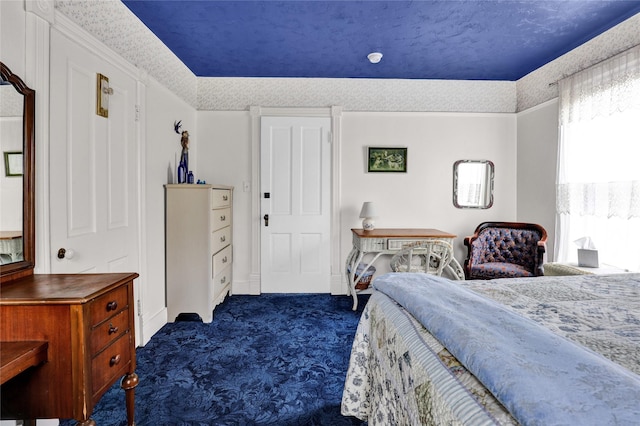 bedroom with a textured ceiling and dark carpet