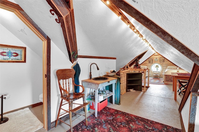 sitting room featuring lofted ceiling and a textured ceiling