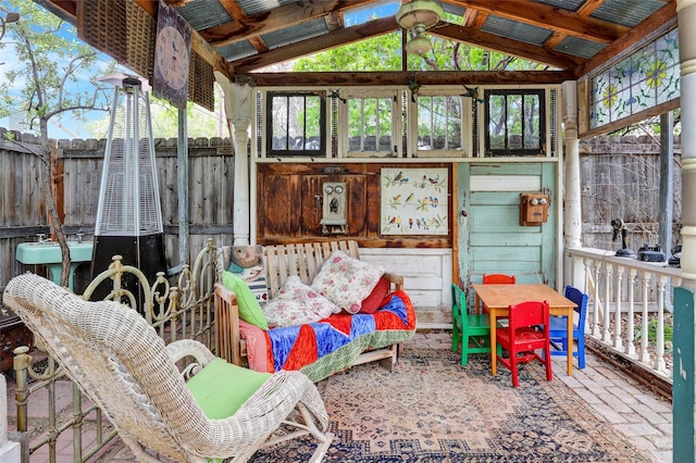 sunroom featuring vaulted ceiling and plenty of natural light