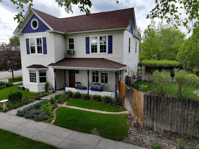 view of front of home featuring cooling unit, a porch, and a front lawn