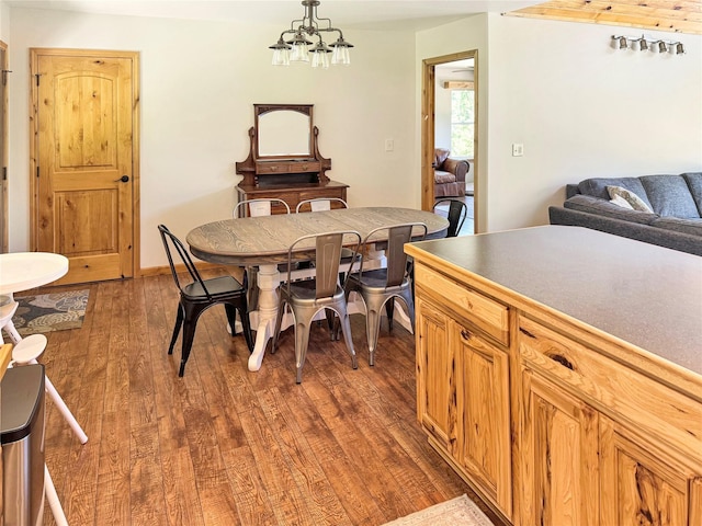 dining area with dark wood-style floors and a chandelier