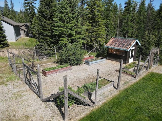 view of property's community with an outbuilding, a garden, and a yard