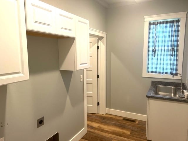 clothes washing area with cabinets, dark hardwood / wood-style flooring, electric dryer hookup, and sink