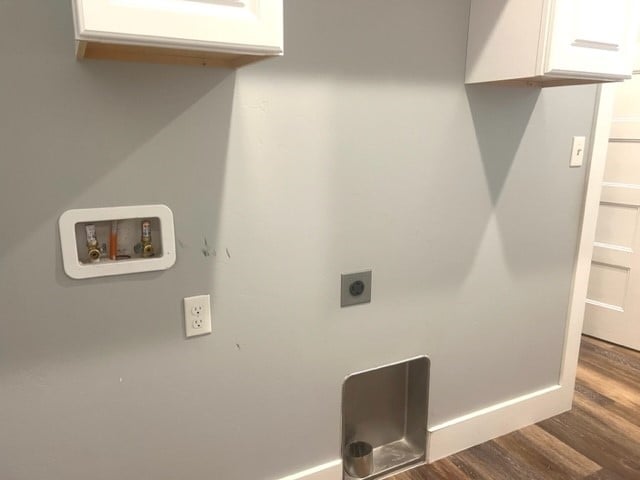 laundry room with electric dryer hookup, hookup for a washing machine, dark hardwood / wood-style flooring, and cabinets