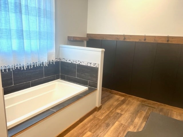 bathroom with hardwood / wood-style flooring and a washtub