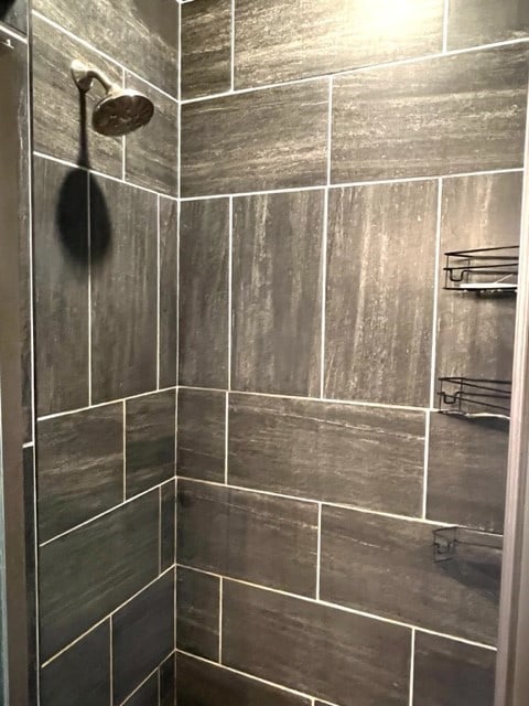 interior details featuring a tile shower