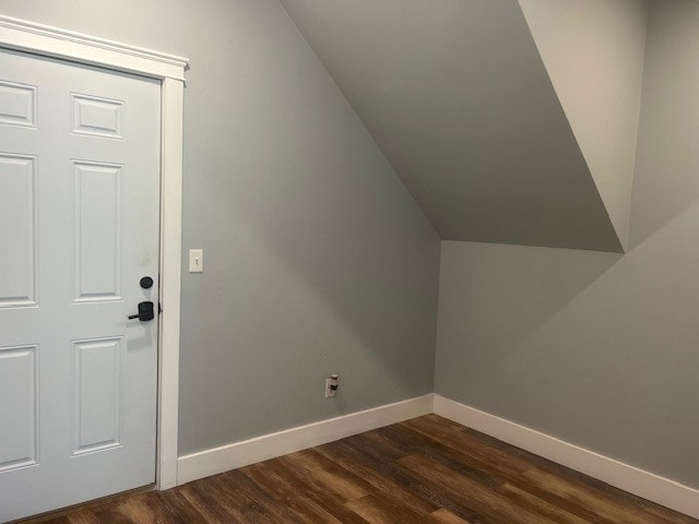 bonus room with dark wood-type flooring and lofted ceiling