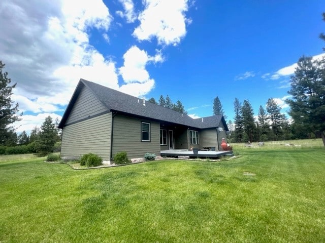 rear view of house featuring a lawn and a wooden deck