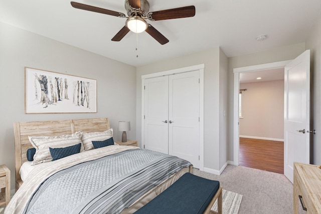 carpeted bedroom with ceiling fan and a closet