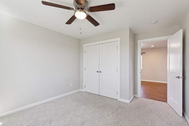 unfurnished bedroom featuring light carpet, ceiling fan, and a closet