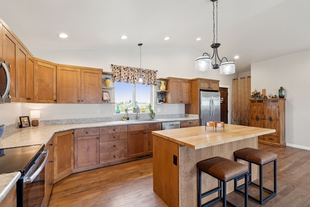 kitchen with a center island, sink, appliances with stainless steel finishes, dark wood-type flooring, and wood counters