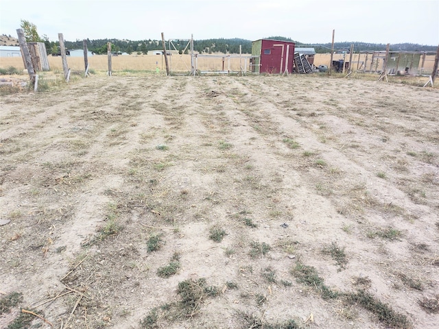 view of yard with a storage shed and a rural view