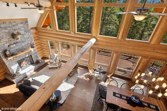 living room featuring a fireplace, a high ceiling, dark hardwood / wood-style flooring, and rustic walls