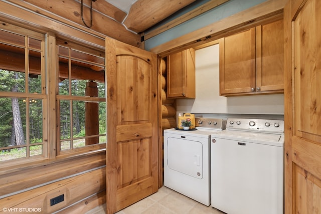 laundry room with cabinets, light tile patterned floors, and washing machine and dryer