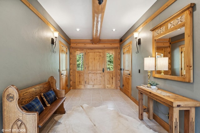 tiled entryway featuring beamed ceiling