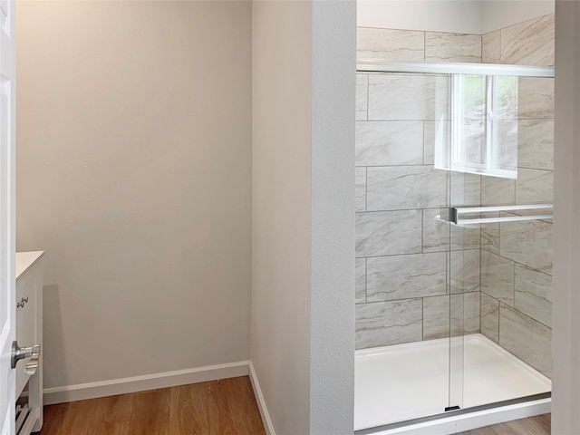 bathroom featuring a shower with shower door, wood-type flooring, and vanity