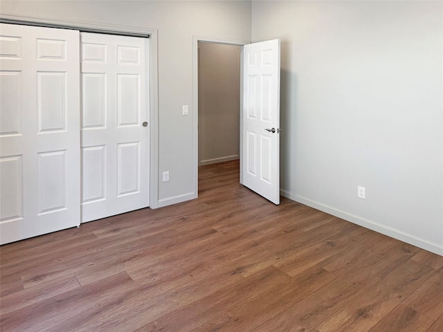 unfurnished bedroom with a closet and hardwood / wood-style flooring