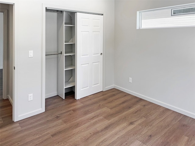 unfurnished bedroom with hardwood / wood-style flooring and a closet