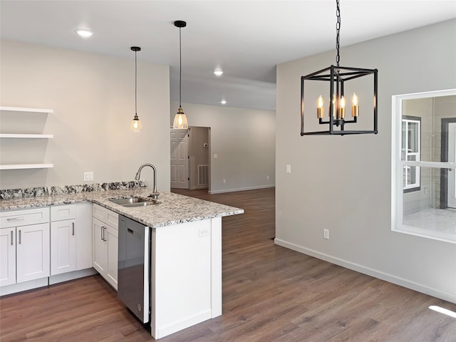 kitchen featuring dark hardwood / wood-style floors, kitchen peninsula, dishwasher, decorative light fixtures, and sink