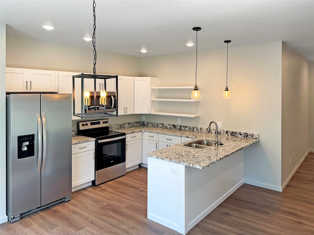 kitchen with stainless steel appliances, hardwood / wood-style flooring, and kitchen peninsula