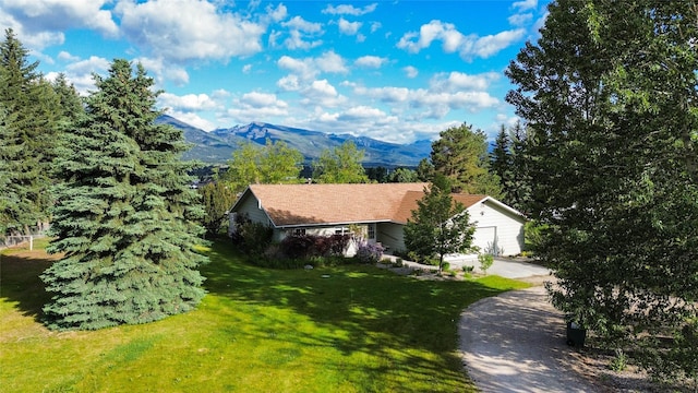 exterior space with a mountain view and a front lawn