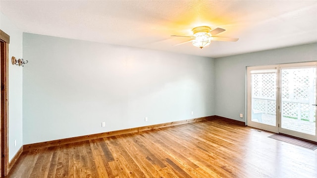 spare room with hardwood / wood-style flooring and ceiling fan