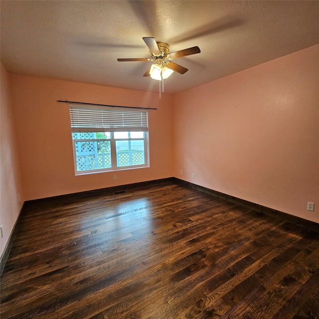 unfurnished room with dark wood-type flooring and ceiling fan