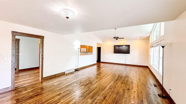 unfurnished living room featuring wood-type flooring, vaulted ceiling, and ceiling fan