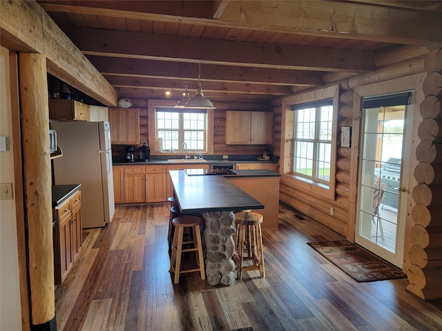 kitchen featuring beamed ceiling, wood ceiling, dark wood-type flooring, and stainless steel refrigerator