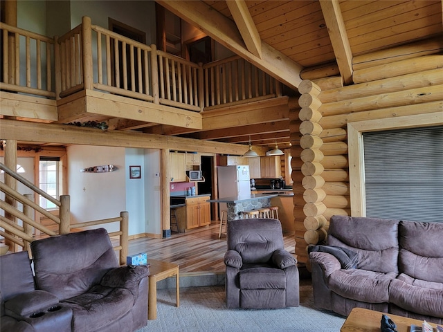 living room with a towering ceiling, light wood-type flooring, wooden ceiling, and beam ceiling