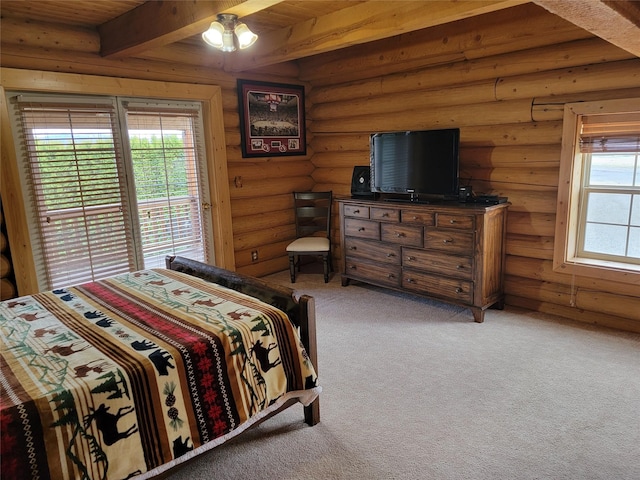 carpeted bedroom with beamed ceiling, rustic walls, multiple windows, and ceiling fan