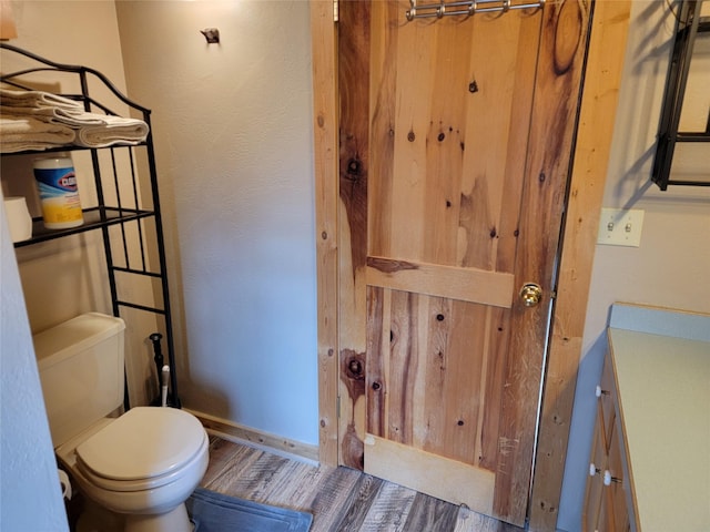 bathroom featuring hardwood / wood-style flooring and toilet