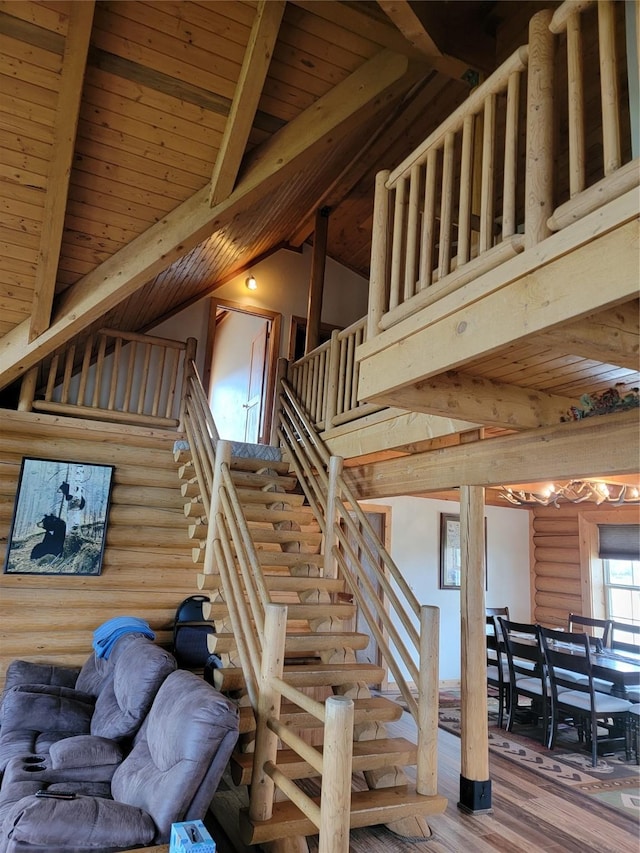 staircase with high vaulted ceiling, wood-type flooring, wood ceiling, and log walls