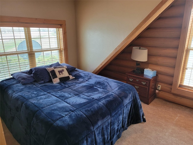 bedroom with multiple windows, rustic walls, and carpet floors